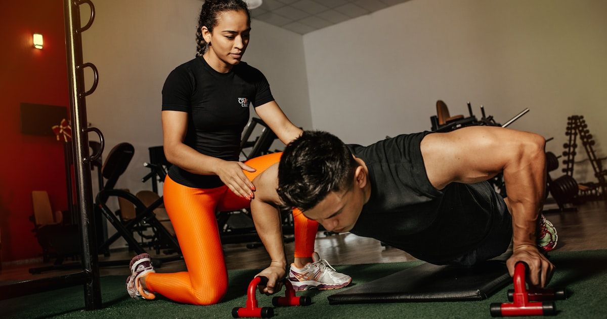 Golf fitness coach reviewing assessment data with a player on the training field